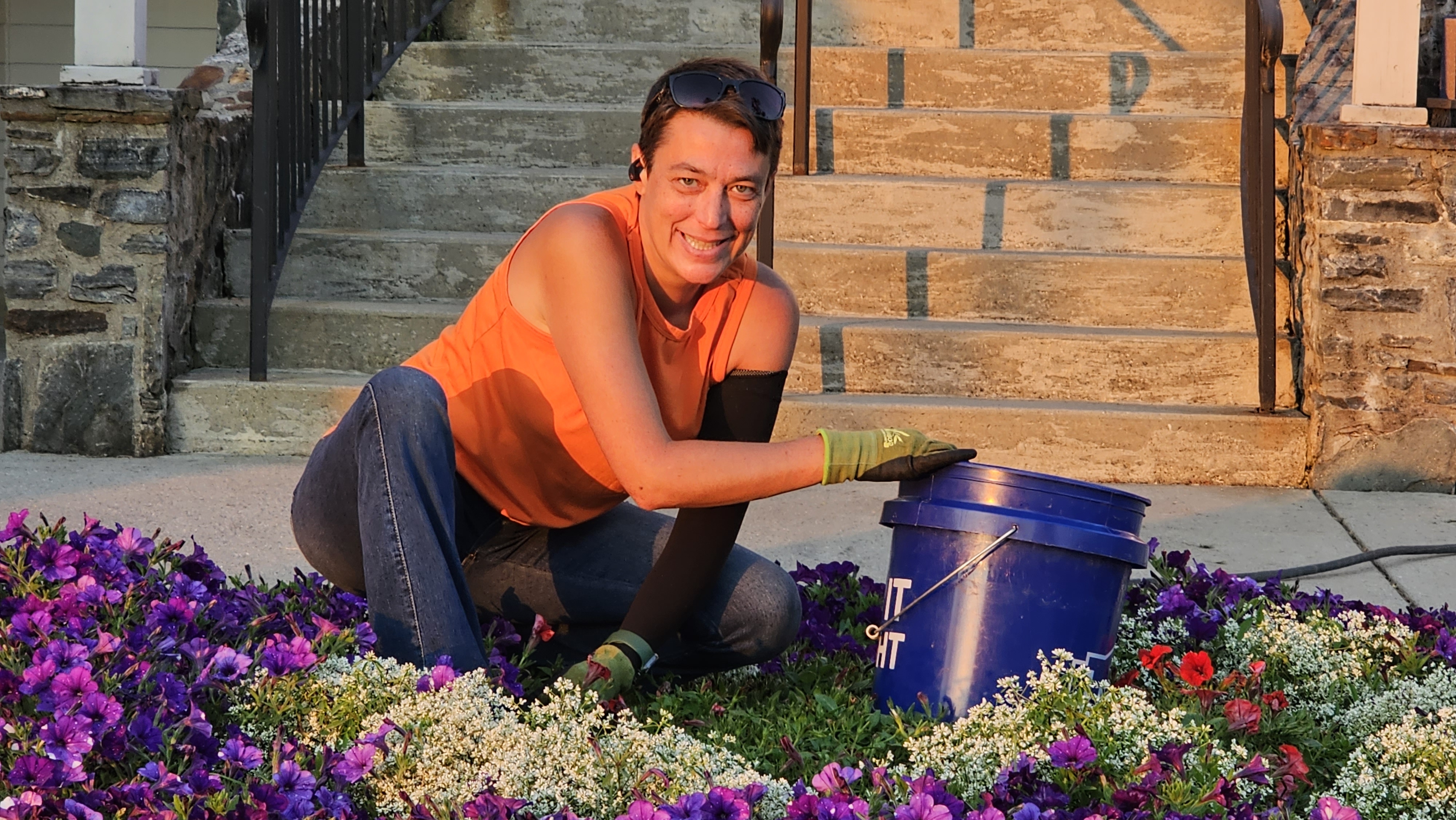 Holly tending a colorful flower bed with gardening gloves and a planting bucket
